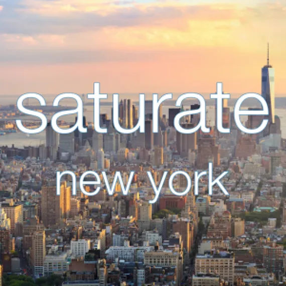 Sunset over New York City skyline with pastel clouds and distant skyscrapers