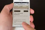 Hand holding a smartphone displaying a website with text.